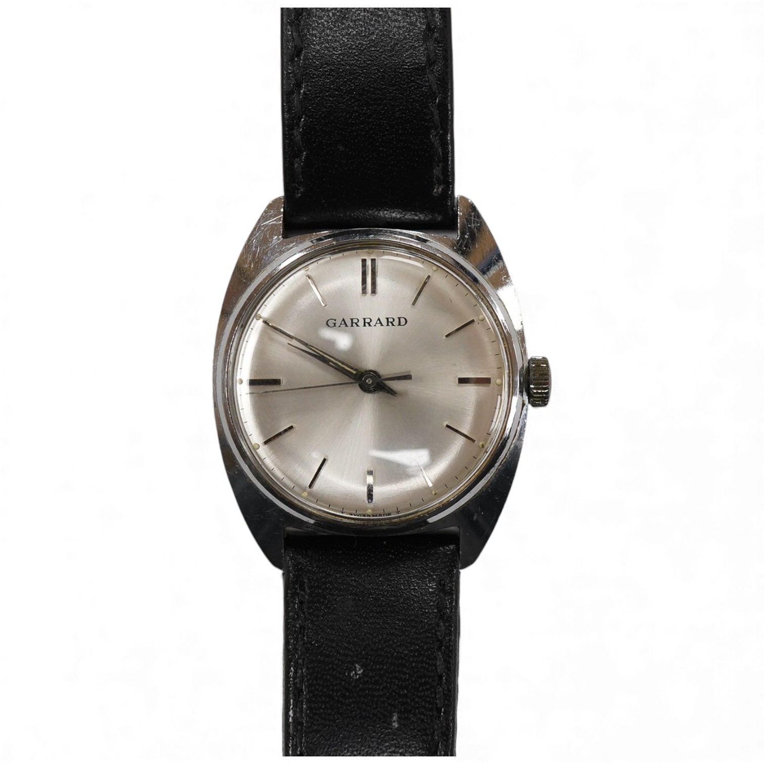 A gentleman's stainless steel manual wind wrist watch, retailed by Garrard, with baton numerals, case diameter 33mm, on a black leather strap.